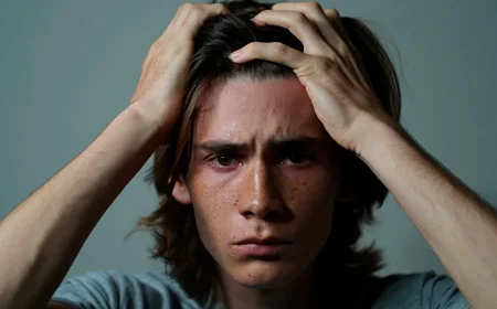 Парень держится за голову руками